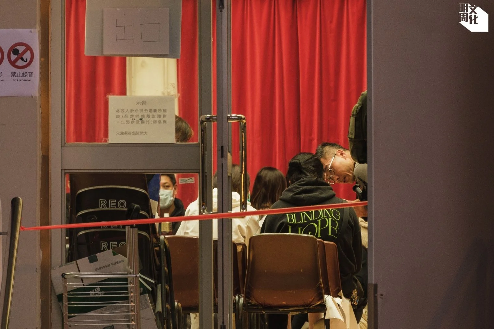 港府在大埔社區會堂設遺體辨認處,有家屬身穿日本視覺系樂隊THE GAZETTE的「Blinding Hope」衛衣翻閱遺體相簿。