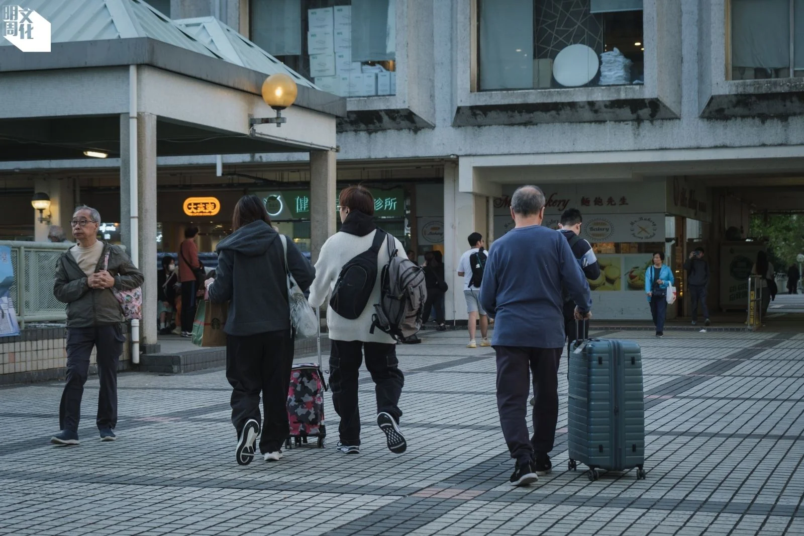 陳伯(右)拖著新買的行李箱,隨兒子前往臨時住宿。