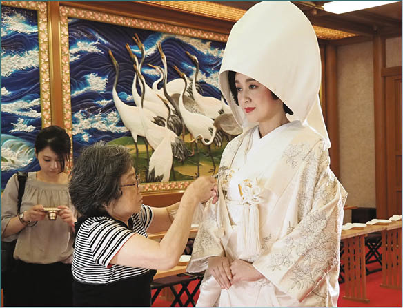 藤原紀香穿上日本傳統新娘服白無垢 即內外完全純白色的和服 要由專人協助穿著 整理 明周娛樂
