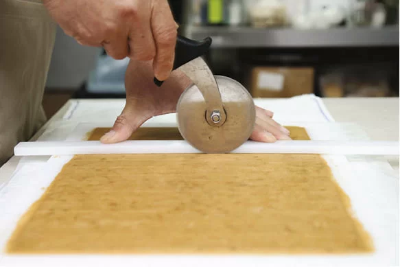 將材料攪拌後平鋪，再切成小方塊，之後要經過三次冷藏，令曲奇口感更佳。