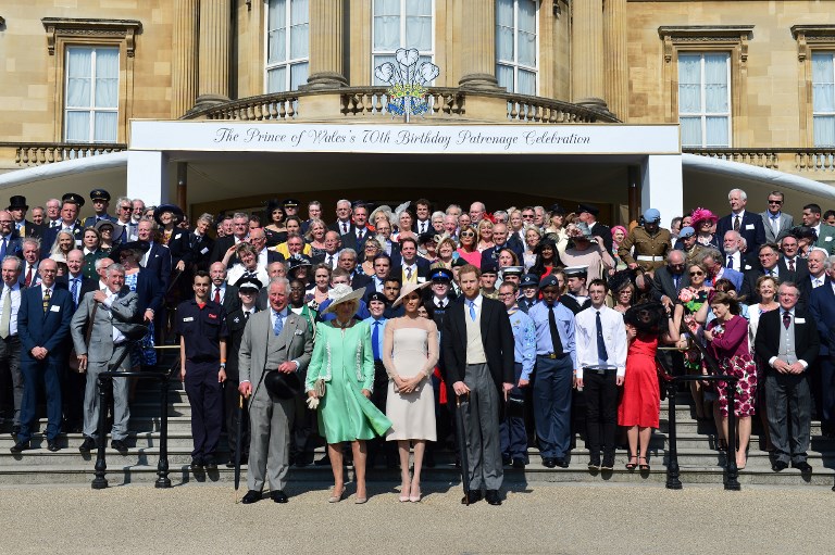 (Front row L-R) Britain's Prince Charles, Prince of Wales, his wife Britain's Camilla, Duchess of Cornwall, Britain's Meghan, Duchess of Sussex, and her husband Britain's Prince Harry, Duke of Sussex (unseen), pose during the Prince of Wales's 70th Birthday Garden Party at Buckingham Palace in London on May 22, 2018. The Prince of Wales and The Duchess of Cornwall hosted a Garden Party to celebrate the work of The Prince's Charities in the year of Prince Charles's 70th Birthday. / AFP PHOTO / POOL / Dominic Lipinski