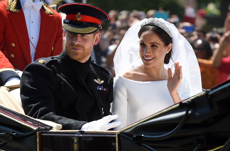 Britain's Prince Harry, Duke of Sussex and his wife Meghan, Duchess of Sussex wave from the Ascot Landau Carriage during their carriage procession on the Long Walk as they head back towards Windsor Castle in Windsor, on May 19, 2018 after their wedding ceremony. / AFP PHOTO / Oli SCARFF