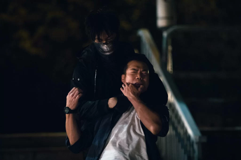 飾演海關關員的謝天華被從後箍頸，狀甚痛苦。