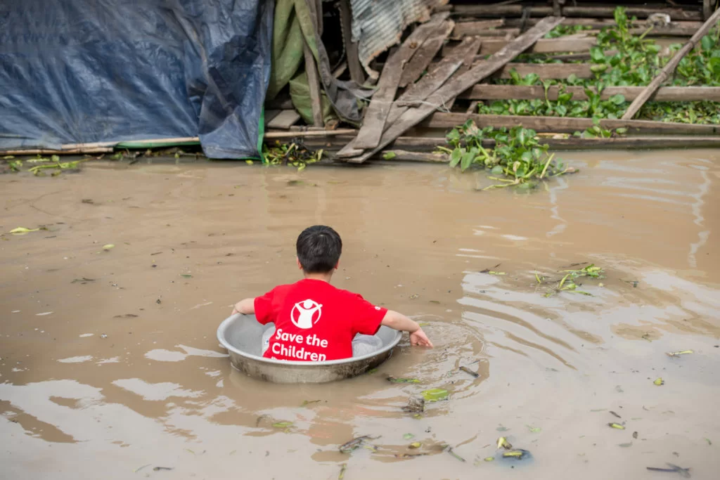 在水上村莊，村民以鐵盆作渡河工具，Cathy的子女們也試坐。