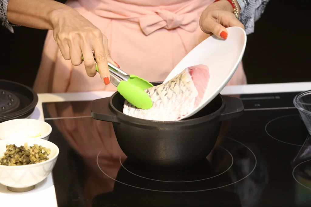 1先將材料放入鑄鐵鍋,豆腐卜本身有油,放在最底層,之後放荵段,因為荵段在鍋內蒸焗過程也會帶出一點水分。 2再放入鯇魚、薑絲。 3放入浸過的銀魚仔及浸過的梅菜,浸的原因是去沙及不會太鹹。