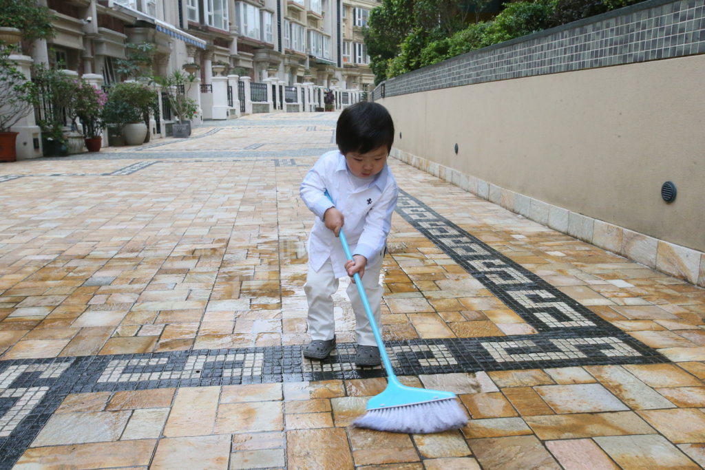 歲半的劉晴，拿起掃把掃污水，有板有眼。