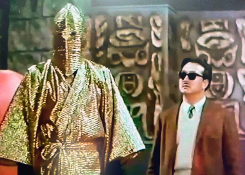 《黑玫瑰與黑玫瑰》的大反派找來從影以來從未演過反派的影帝級演員上陣。綽號「金閻羅」，所以藏身地底，兼且由頭「金」到落膝頭。這個造型本來沒可能猜到飾演者是誰，唯是聲音出賣了他，只要一開腔，他的臉容神態，即時浮現所有人眼前。