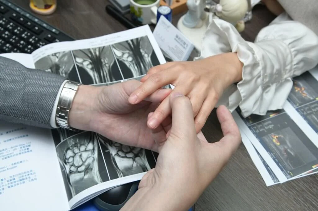 陳醫生示範如何為患者檢查手指關節