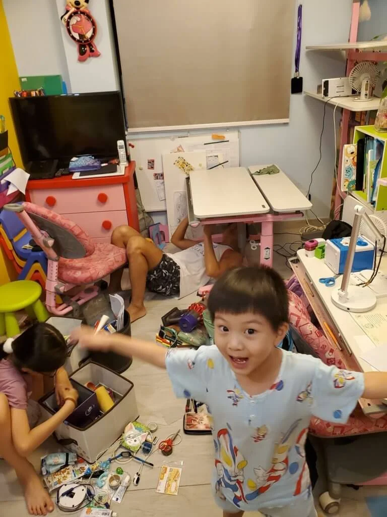胡諾言躺在地上修理小朋友書桌