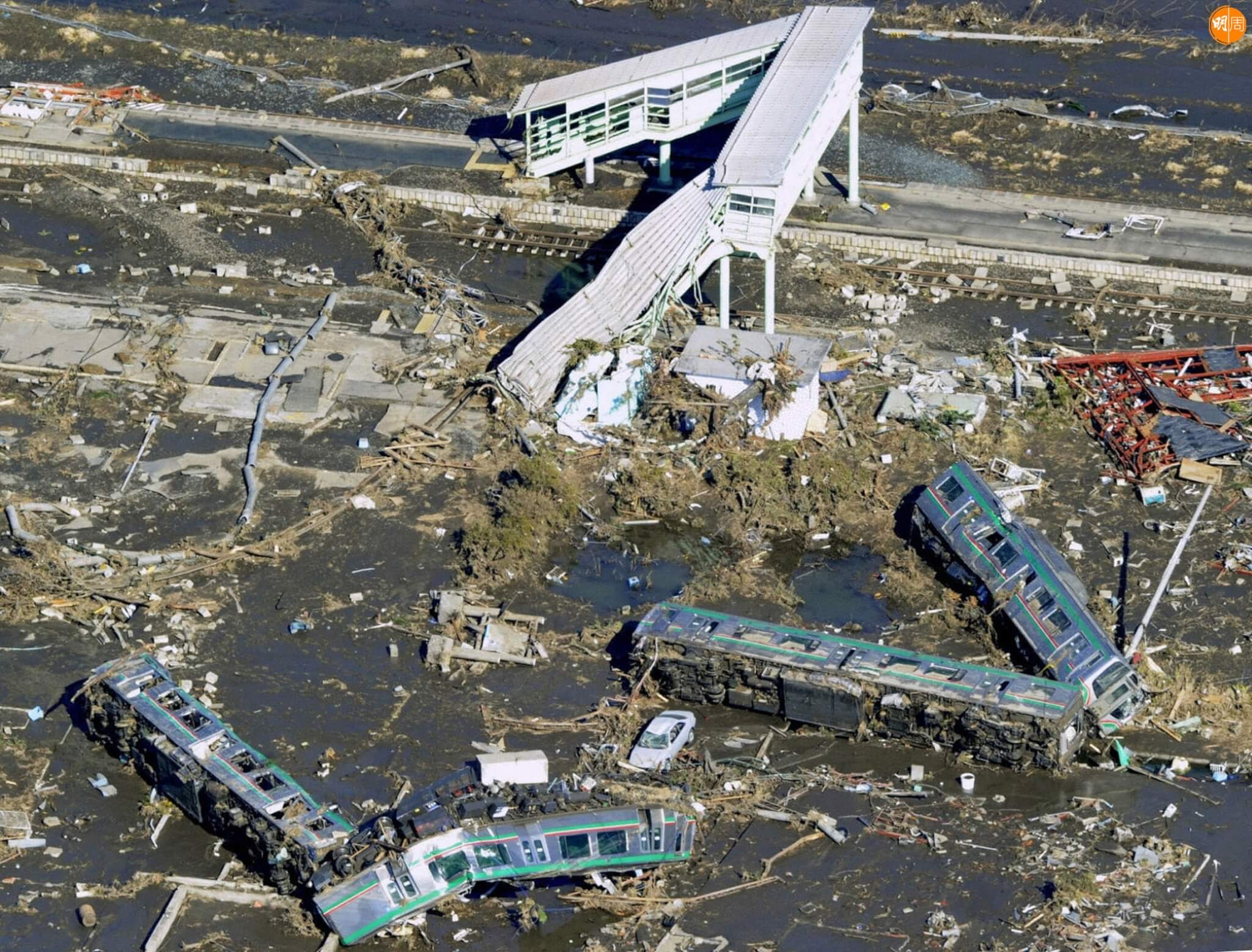 JON1031257. Vagones de un tren se ven en el suelo después de volcarse al ser barridos por el tsunami en la ciudad de Shinchi en Prefectura de Fukushima, Japón. Más de 1.000 personas están desaparecidas después del gran terremoto del viernes y el posterior tsunami en el noreste de Japón. XINHUA-NOTIMEX/FOTO/KYODO/COR/DIS/ (Photo by KYODO / NOTIMEX / Notimex via AFP)