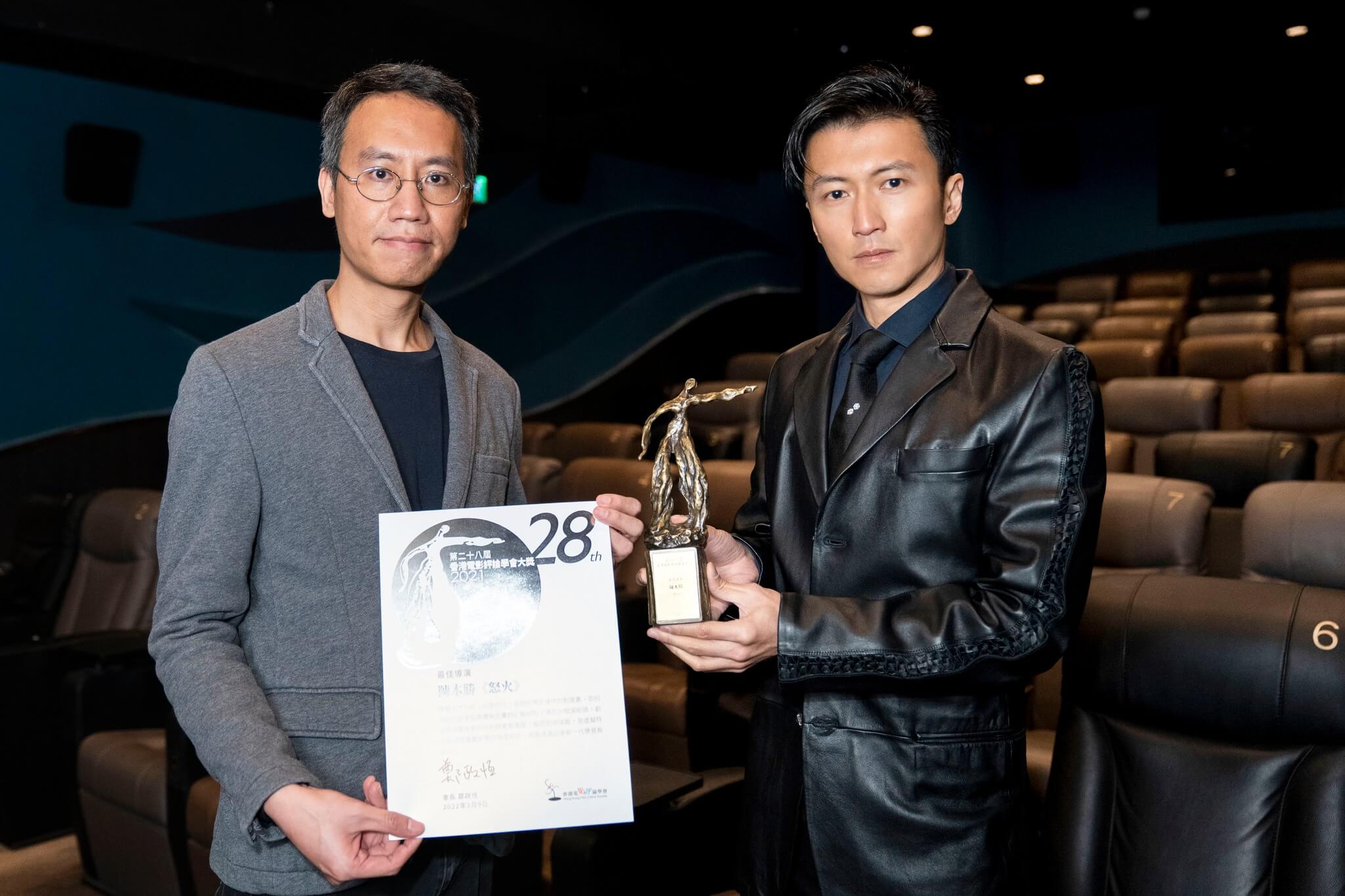 謝霆鋒代表陳木勝，從香港電影評論學會現任會長鄭政恆手上接過獎項
