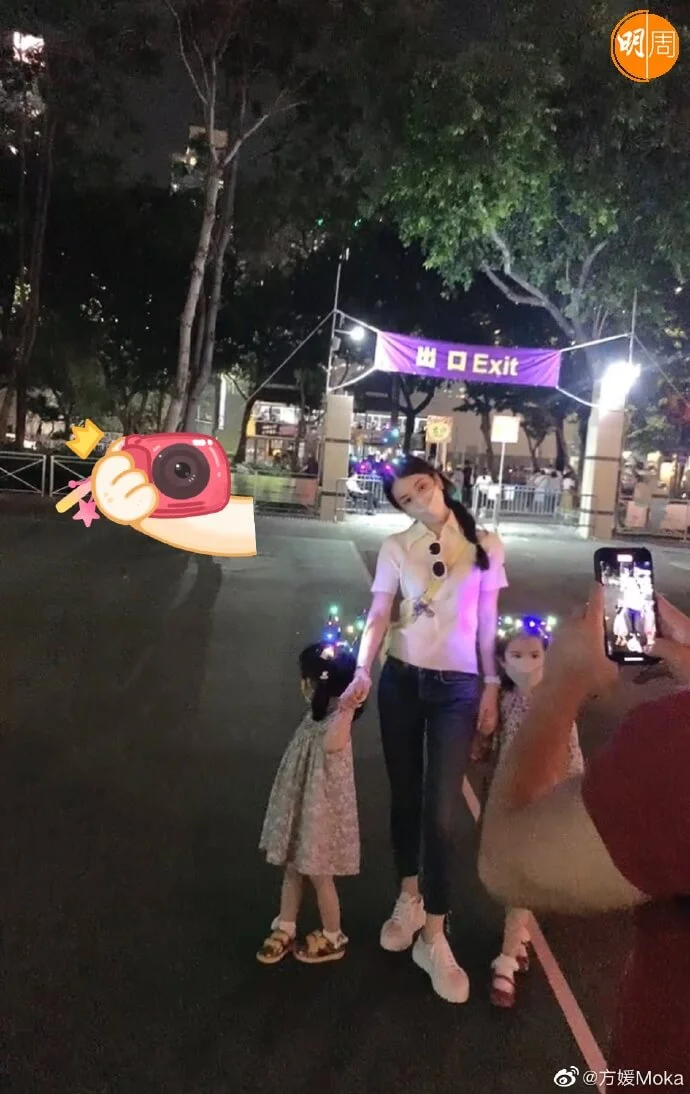 城城揸機幫妻女在維園拍照。