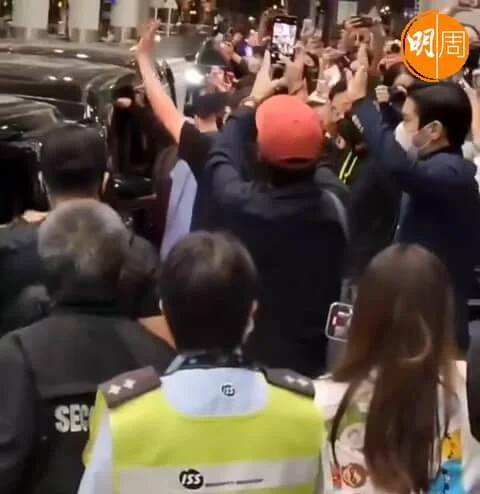 戴紅帽的藝聲，舉起電話拍攝現場情況留念。