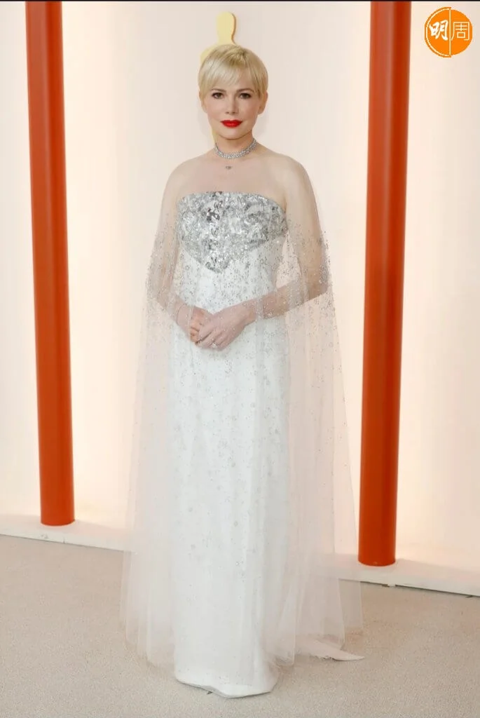 米雪威廉絲穿Chanel繼續優雅 以《法貝曼:造夢大師》母親角色出戰影后的米雪威廉絲(Michelle Williams),在紅地毯上總是優雅的化身,今年的奧斯卡頒獎典禮就是一個完美例子。她身穿Chanel的美麗新娘風格白色禮服,配有透明披風,加上精緻的配飾,高貴優雅。