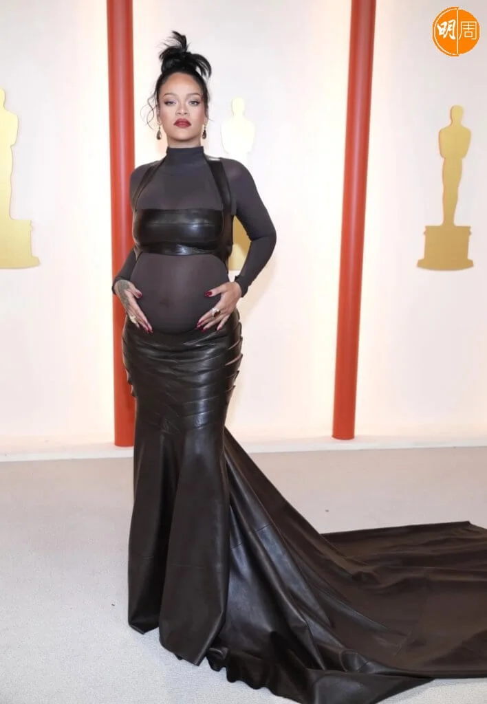 Rihanna最型爆孕婦晚裝 挺巨肚演唱入圍最佳電影歌曲《黑豹2》主題曲的美國女歌手Rihanna,擁有最型爆的孕婦造型,穿著Alaïa皮裙及透明上衣組成的晚裝。