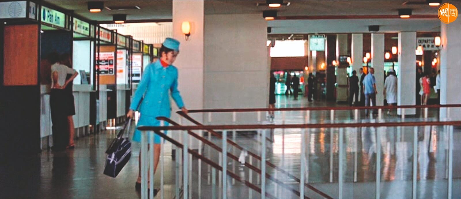 一九七四年的啟德機場二樓。一身彩藍空姐服的井莉出差回港。但當年二樓是送機閘口，一樓才是接機大廳。這一幕飾演空姐的井莉單人匹馬，同行機隊呢？她人丁單薄，但為了她心急會情人而拍的兩個鏡頭，卻「勞師動眾」。 