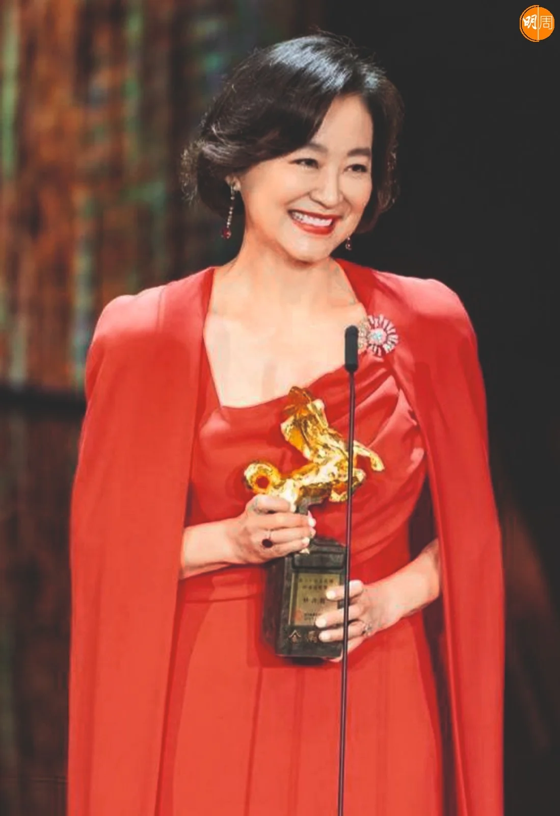 這一襲紅色禮服，似是為十年前出席金馬50的那一襲紅色禮服作出減法。去了珠寶，少了手套，整體從線條的修長效果考量，當然也在清湯掛麵的髮型上得到響應。